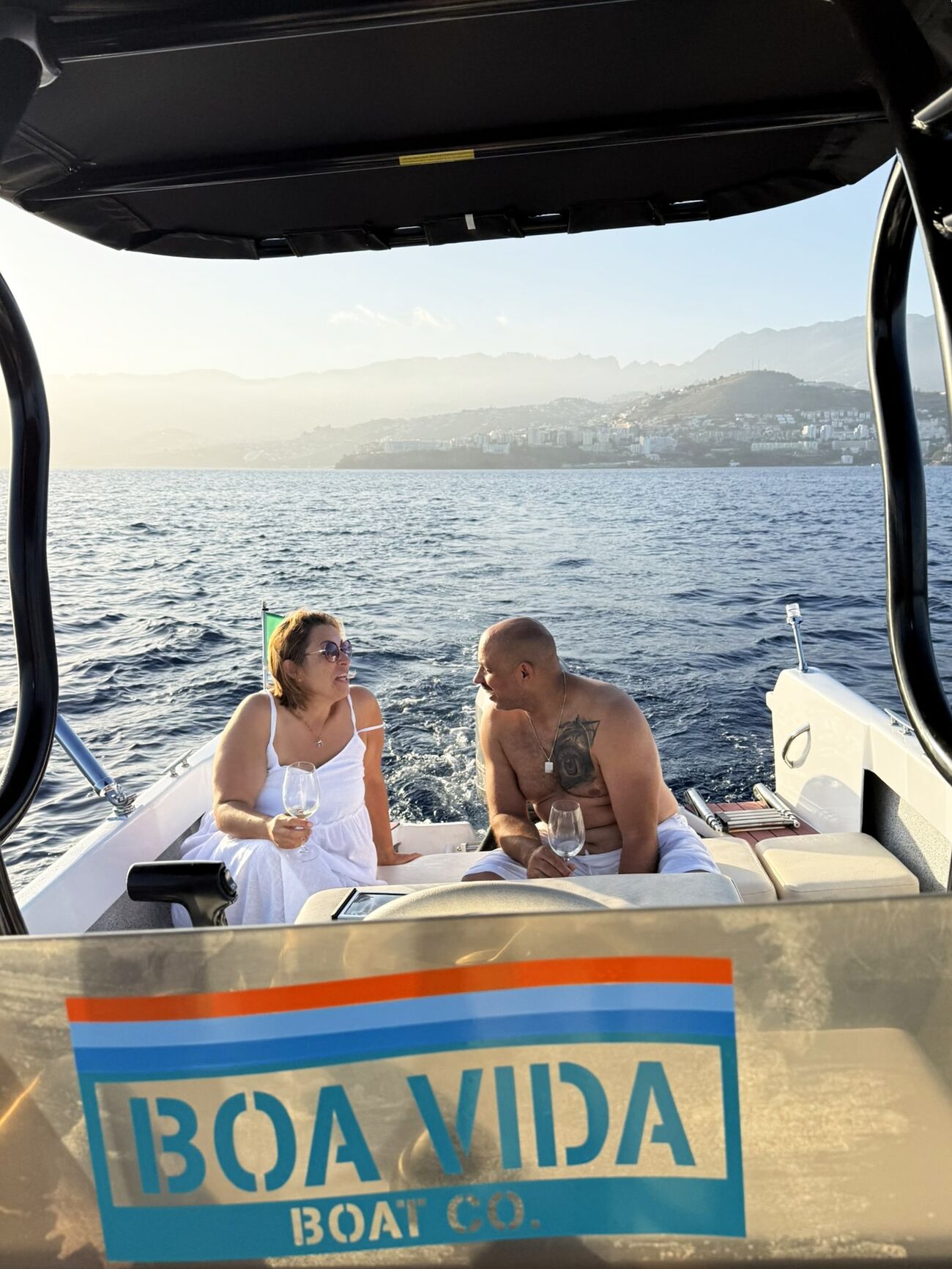 Guests enjoying a glass of wine aboard Boa Vida at golden hour